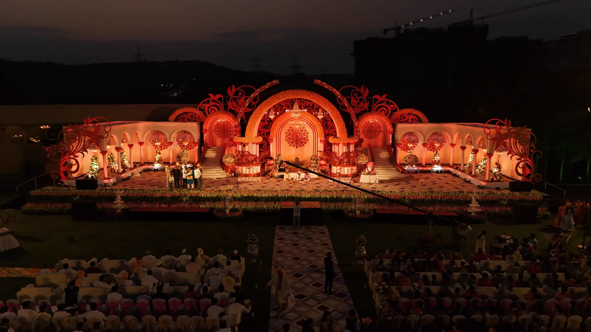 A wedding stage lit at night, seen from above the seated guests